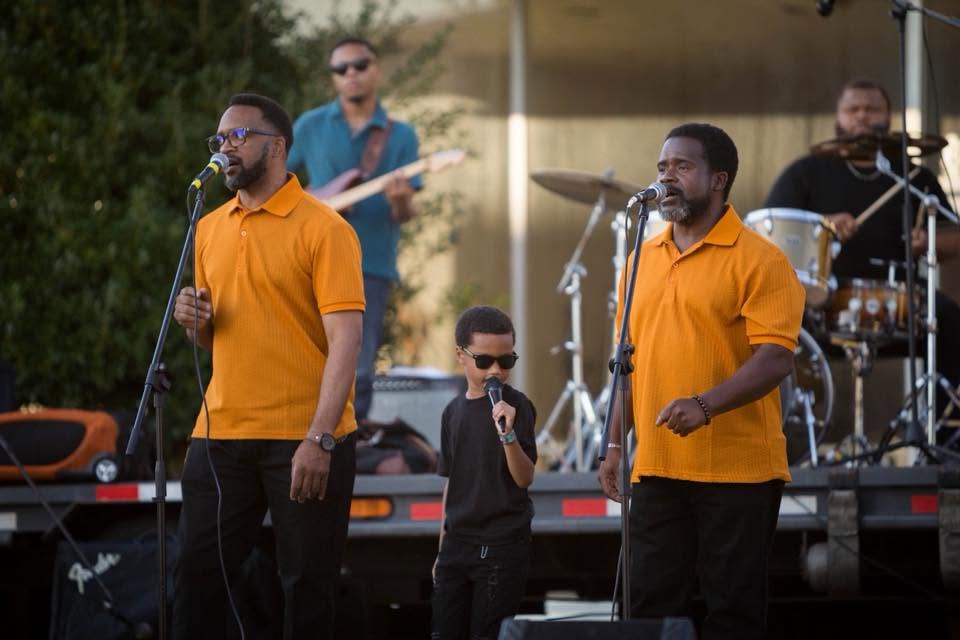 Gospel singers performing onstage with a young vocalist and live band at Grenada Gospel Fest in Grenada, Mississippi.